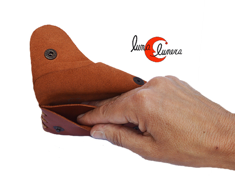 Original monedero de piel con compartimentos y cierre a presión.