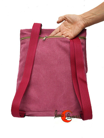 Mochila plana de tela con tapa. El compartimento principal abre por la espalda como cremallera antirrobo.