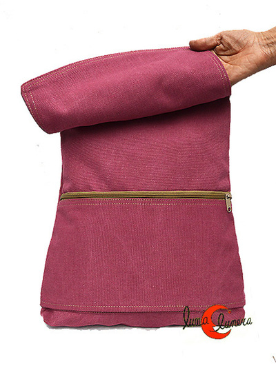 Mochila de loneta plana con tapa. Tiene un bolsillo grande debajo de la tapa.