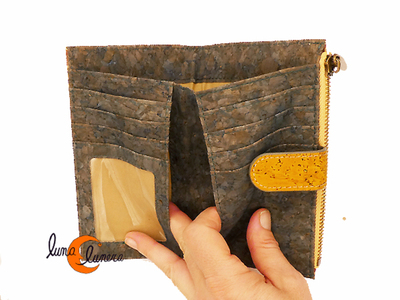 Cartera mediana de corcho con monedero con cremallera. SE enseña el modelo, los colores pueden ser diferentes al producto que está en venta.