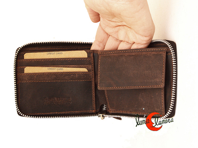 Cartera de piel con cremallera al rededor.