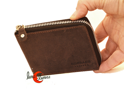 Cartera de piel con cremallera al rededor.