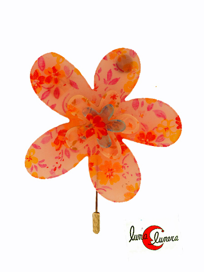 Broche de aguja con flor grande transparente en tonos rosa.