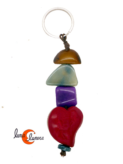 llavero de semillas de tagua. Tira larga con corazón rojo.