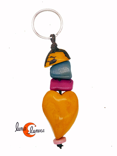 llavero de semillas de tagua. Tira larga con corazón amarillo.