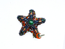 Broches de porcelana. Estrella de mar de pedrería sobre terciopelo naranja, pequeña.