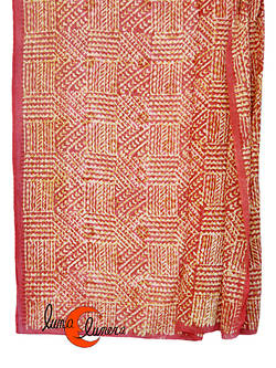 Pareo-fular de algodón rojo teja con dibujos beig y mostaza.