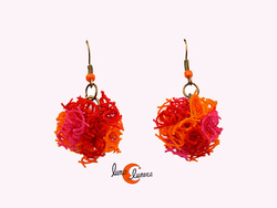 Cordelia, pendientes hechos con redes de pesca. Pompom corto naranjo y rojo.